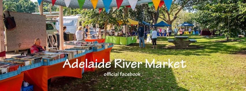 Outdoor market stalls with handmade goods, art, and crafts